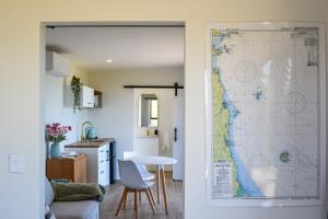 a door leading into a kitchen with a map on the wall at Tūhua View Retreat in Waihi Beach