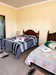 two beds sitting next to each other in a room at Pousada Efraim in Tiradentes