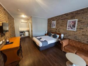 a hotel room with a bed and a couch at Homestead Motor Inn & Apartments in Bendigo +48 photos