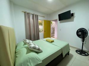 a room with a bed with a fan and a window at La Casa Hostal Vijes in Vijes