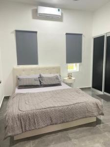 a bedroom with a large bed with two windows at Singgah Salam Stay in Parit Raja +6 photos