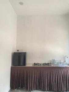 a kitchen with a stove with a brown curtain at Singgah Salam Stay in Parit Raja