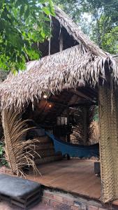 a thatched roof of a house with a wooden deck at Camping AlterArte Ecovila in Santarém