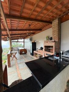 a kitchen and living room with a stone fireplace at Estação Serra Negra in Bezerros