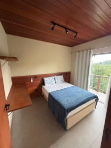 a bedroom with a bed and a large window at Estação Serra Negra in Bezerros