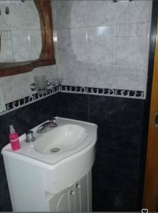 a bathroom with a white sink and a mirror at Departamento Cura Brochero in Villa Cura Brochero