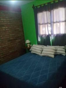 a bedroom with a blue bed with a window at Departamento Cura Brochero in Villa Cura Brochero