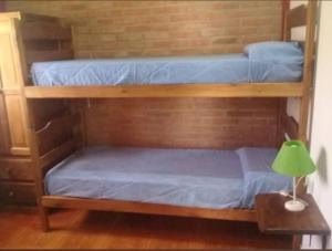 two bunk beds in a room with a lamp at Departamento Cura Brochero in Villa Cura Brochero
