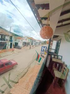a view of a street from a building with a red car at Hotel Bera-k in Villa de Leyva