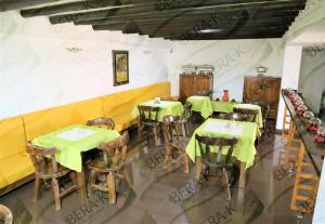 a dining room with green tables and chairs at Hotel Bera-k in Villa de Leyva