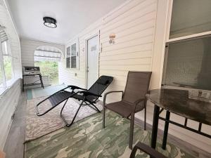 a porch with two chairs and a table on a house at Completely renovated for you Mountain View Cottage in Charleston