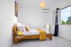 a bedroom with a bed and a window at L' É'sens Karaïbes in Les Abymes