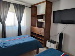 ein Schlafzimmer mit Fernseher und Bett und einem Fernseher in der Unterkunft Centro Queretaro Hospedaje Castillo in Casa Blanca La Corregidora