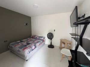 a bedroom with a bed and a desk and a fan at Habitaciónes Entradas Privadas independientes tipo APTO in Valledupar