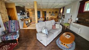 a living room with a couch and a table at Suite 3 Flèche du fjord vue Saguenay Mont Valin in Saint-Fulgence