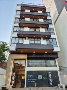 a tall apartment building with a store front at Apartamento prox a Arena Niteroi, Uff e Barcas in Niterói