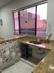 a bathroom with a sink and a window at Apartamento - Vila Isa in Governador Valadares