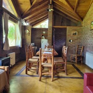 a dining room with a wooden table and chairs at Arroyo Escondido in Trevelín