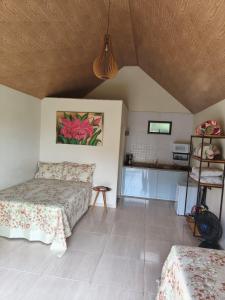 a bedroom with two beds and a table at Chalés Pôr do Sol Alto Caparaó in Caparaó Velho