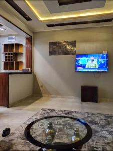 a room with a table and a tv on the wall at Ni HOME & RELAX in Ruhengeri