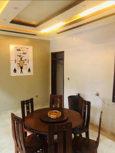 a dining room with a wooden table and chairs at Ni HOME & RELAX in Ruhengeri
