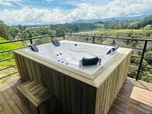 a jacuzzi tub on a deck with a view at Cabaña Monte cristo in Guatapé +1 photo