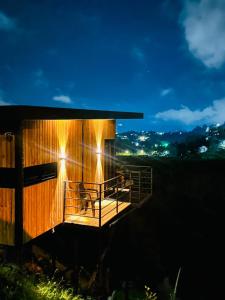a building with a dog sitting on a deck at night at Cabaña Monte cristo in Guatapé