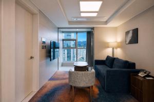 a living room with a blue couch and a window at Matie Busan Harbor City in Busan +48 photos