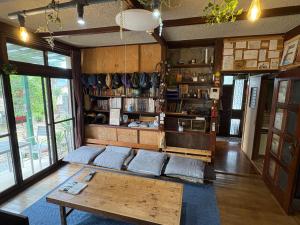 a living room with a table and a book shelf at Norishicoauto Guesthouse in Chikushino