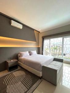 a bedroom with a large bed and a window at Al Andalus Resort Puncak in Puncak +90 photos