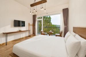 a bedroom with a large bed and a large window at Romeo & Juliet's Hồ Tuyền Lâm Dalat in Da Lat