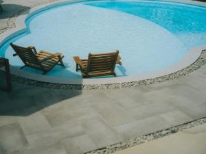 two chairs sitting next to a swimming pool at semilla 名護 沖縄 in Nago +55 photos