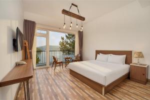 a bedroom with a bed and a balcony with a table at Romeo & Juliet's Hồ Tuyền Lâm Dalat in Da Lat