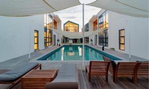 a swimming pool with two chairs and an umbrella at Aldea de Pangsion Pool Villa in Pohang