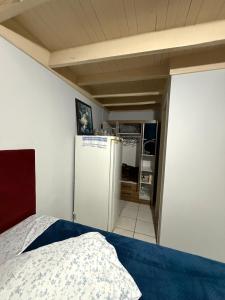 a kitchen with a refrigerator and a bed in a room at Casa Miguel in Lauro Müller +2 photos