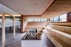 uma sauna com bancos de madeira e um fogão numa sala em Hotel Prokulus em Naturno