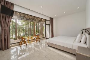 a bedroom with a bed and a desk and a large window at Romeo & Juliet's Hồ Tuyền Lâm Dalat in Da Lat +85 photos
