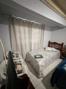 a bedroom with a bed and a window at Casa Miguel in Lauro Müller