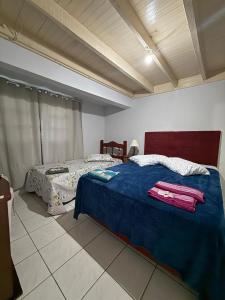 a bedroom with a bed with a blue comforter at Casa Miguel in Lauro Müller