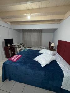 a bedroom with a large bed with a blue blanket at Casa Miguel in Lauro Müller