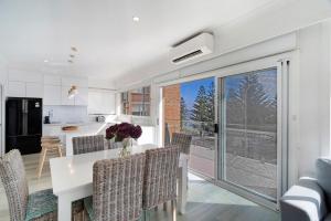 a kitchen and dining room with a table and chairs at Blue Pacific Apartment 8 in The Entrance +18 photos