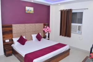 a bedroom with a bed with purple walls at Hotel Exotica Haridwar in Rāiwāla