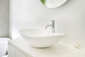 a white bathroom with a sink and a mirror at Blue Pacific Apartment 8 in The Entrance