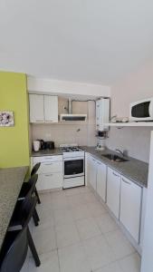 a kitchen with white cabinets and white appliances at Refugio de mar Bahia Creek in Las Grutas