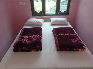 a bed with two pillows on it in a room at Hotel suryoday kharadi in Kutnaur