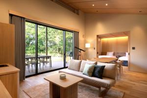 a living room with a couch and a dining room at Nemu Resort Hotel Nemu in Shima