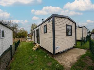 a white tiny house sitting in a yard at Cozy Caravan in Berlare for 6 people in Berlare