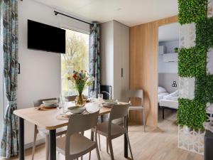 a dining room with a table and chairs and a bedroom at Cozy Caravan in Berlare for 6 people in Berlare