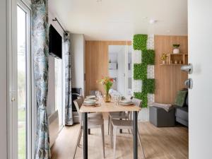 a dining room and living room with a table and chairs at Cozy Caravan in Berlare for 6 people in Berlare