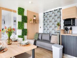 a living room with a couch and a table at Cozy Caravan in Berlare for 6 people in Berlare